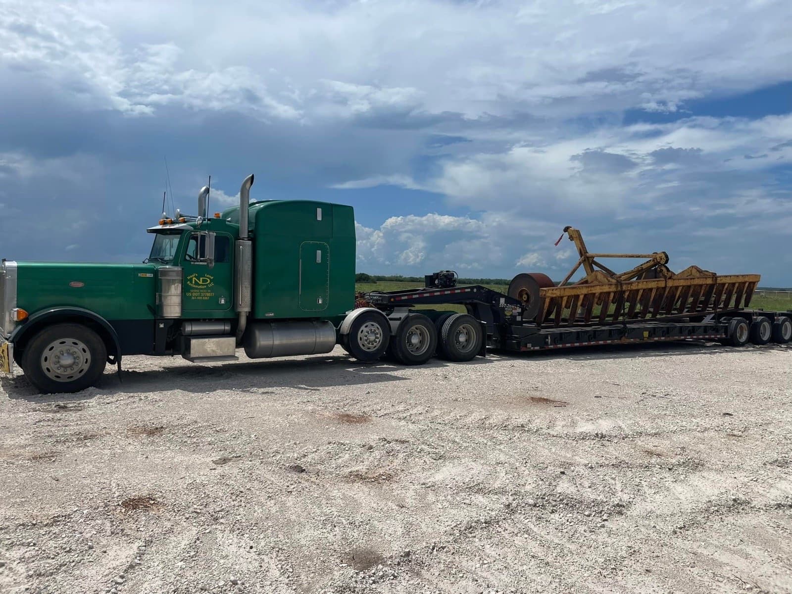 Neal's Land Restoration Peterbilt hauling roller chopper on lowboy trailer across South Texas